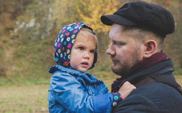 father holding daughter while she cries