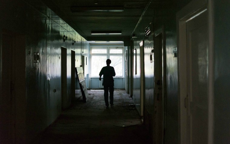 person in dark alley/corridor