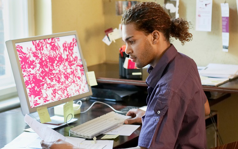 social worker in office looking at computer and papers