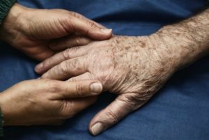 Person holding hand of older person