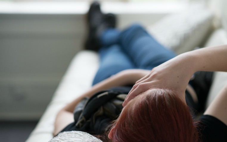 teenage girl lying on sofa