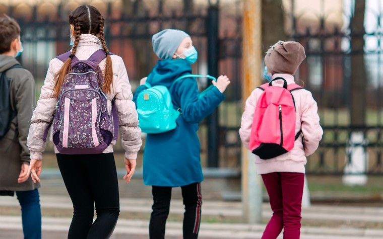 Teenagers on the way to school wearing masks