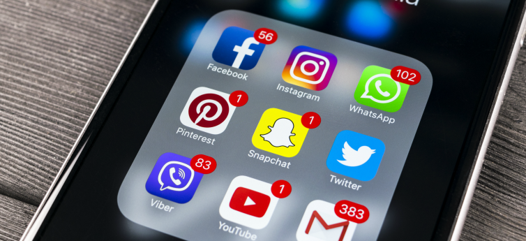 mobile phone showing app icons for Snapchat, Facebook, Instagram, Twitter, Youtube, Whatsapp etc