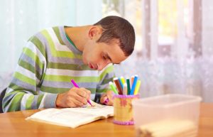 Young man with learning disabilities writing