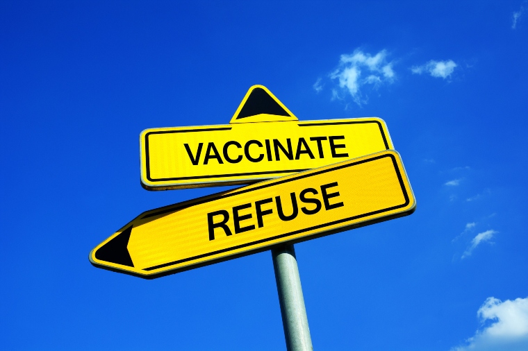 Two signs saying 'vaccinate' and 'refuse'