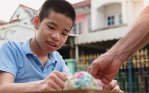 Child with special educational need disability playing with social worker (worker's arm shown)