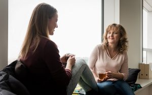 social worker talking to teenage girl drinking tea