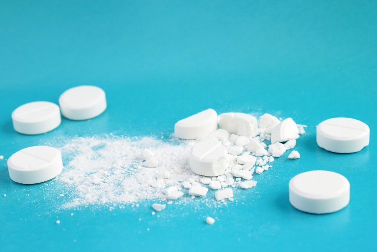 A number of white tablets, some have been crushed
