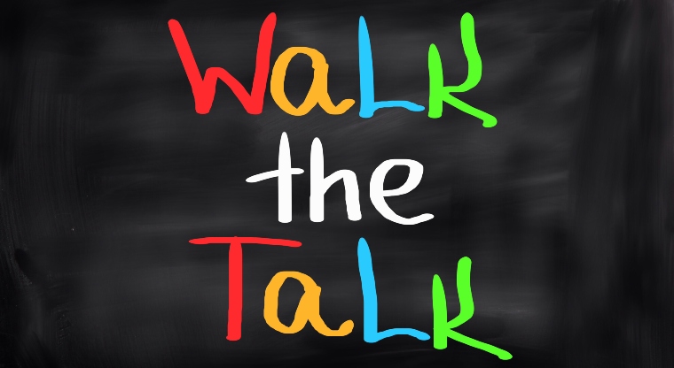 The words 'walk the talk' in colourful letters on a black background