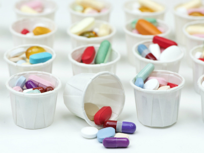 different coloured pills in paper cups