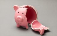 Pink piggy bank that is broken on grey background