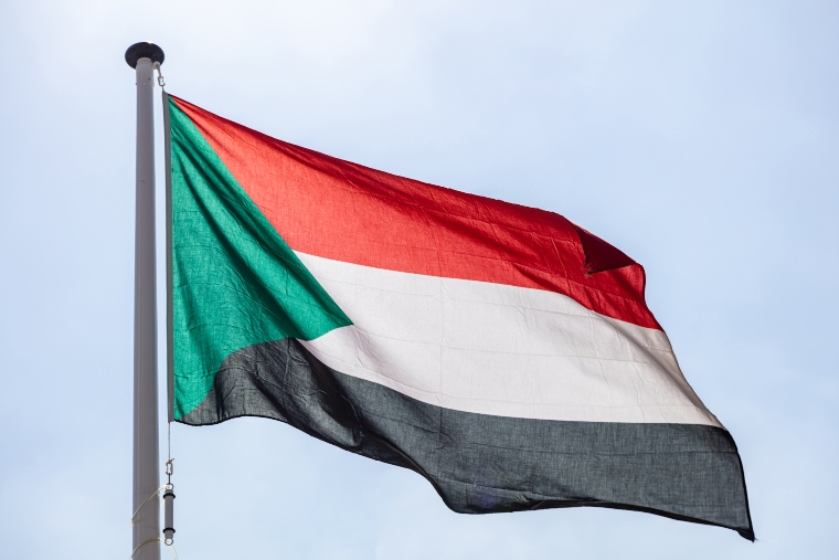 The flag of Sudan, the Republic of Sudan, horizontal red-white-black tricolour with a green triangle at the hoist.