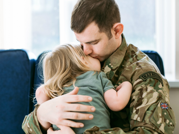 soldier in uniform hugging daughter