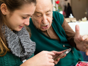 An older man and younger woman looking at a smartphone