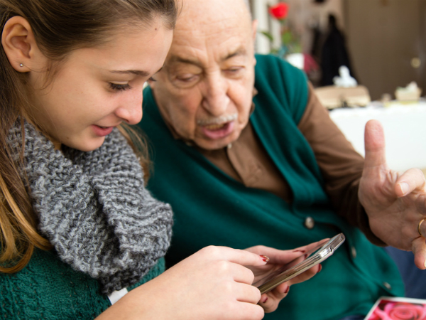 An older man and younger woman looking at a smartphone