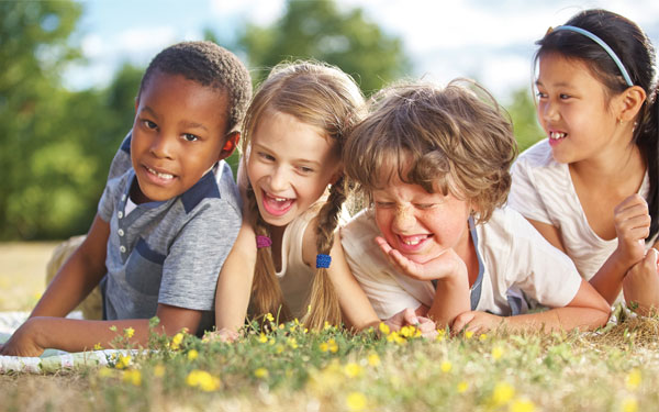 Description of image used in Caritas sponsored feature happy children lying on grass