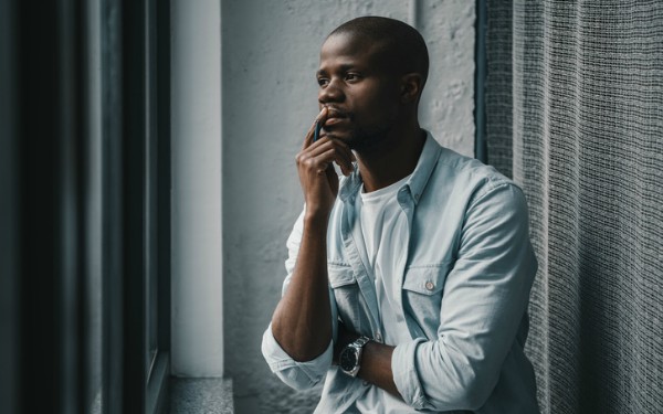 Portrait of young african american man looking at window