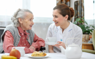 Care worker supporting an older person to eat