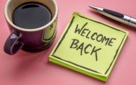 Post-it note with the welcome 'welcome back' next to a cup of coffee