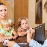 Image of a social worker talking to a family (credit: JackF / Adobe Stock)