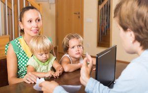 Image of a social worker talking to a family (credit: JackF / Adobe Stock)