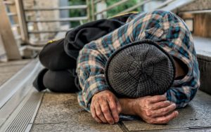 Homeless man sleeping on a step