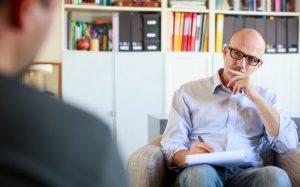 Therapy session, adult man talking to his psychotherapist