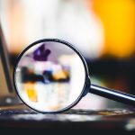 Image of laptop and magnifying glass (credit: Paweł Michałowski / Adobe Stock)