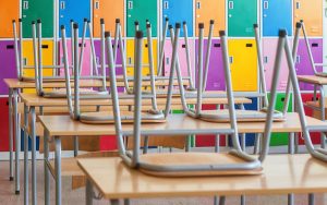 Image of empty classroom with chairs on desks (credit: miriristic / Adobe Stock)