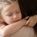 Image of girl embracing foster mother (credit: fizkes / Adobe Stock)