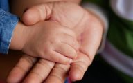 Image of child's hand in grandparent's (credit: Ole_CNX / Adobe Stock)