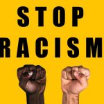 African black fist and caucasian white fist raised calling for freedom and equality on a yellow background. Multicultural fists raised. Stop racism.