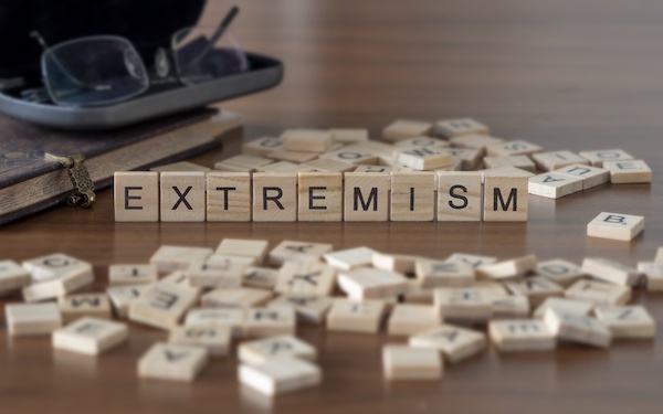 Image of the word 'extremism' represented by wooden letter tiles (credit: shane / Adobe Stock)