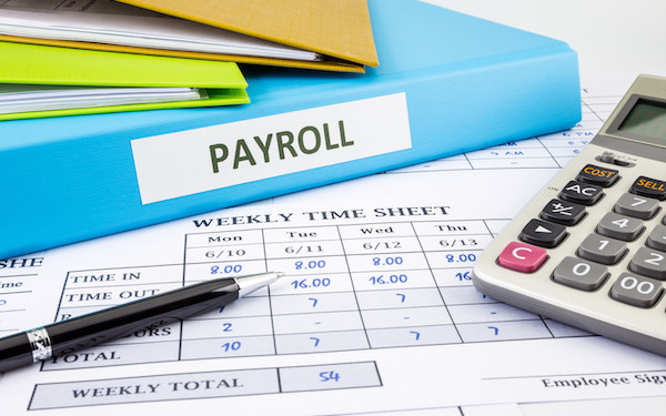 Image of payroll file and calculator (credit: vinnstock / Adobe Stock)