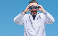 A doctor looking through binoculars