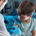 pediatrician vaccinating little boy in the pediatric clinic