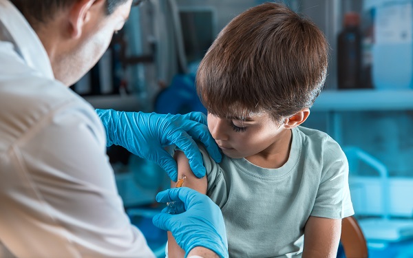 pediatrician vaccinating little boy in the pediatric clinic