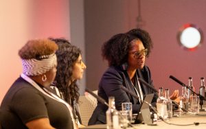 Millie Kerr, Ahmina Akhtar and Shantel Thomas, pictured at Community Care Live, discussing racial inequality in social work
