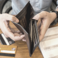 Person holding empty wallet to symbolise cost of living crisis