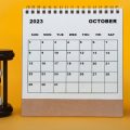 Calendar showing the month October 2023 with a sandtimer and plant