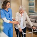 Nurse helping woman rehabilitate in care home