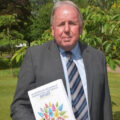 Ray Jones holding a copy of his review of children's social care in Northern Ireland