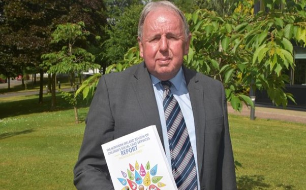 Ray Jones holding a copy of his review of children's social care in Northern Ireland