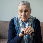 Older woman looking downcast on sofa