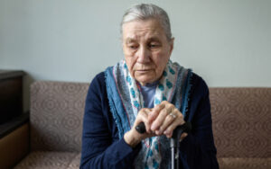 Older woman looking downcast on sofa