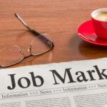 A newspaper on a wooden desk - Job Market