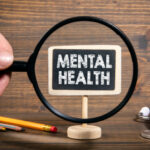 Mental Health. Stress, tension, relationships and work environment concept. Man's hand, holding magnifying glass