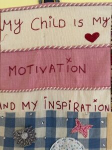 Wall hanging made by Jasmine residents. Text reads: My child is my motivation and my inspiration