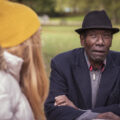 Older man talking to a social worker in the park