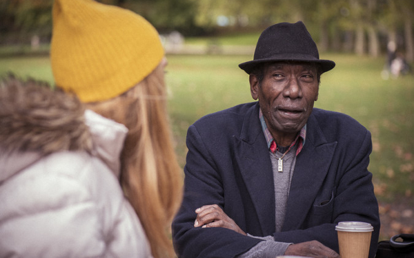 Older man talking to a social worker in the park
